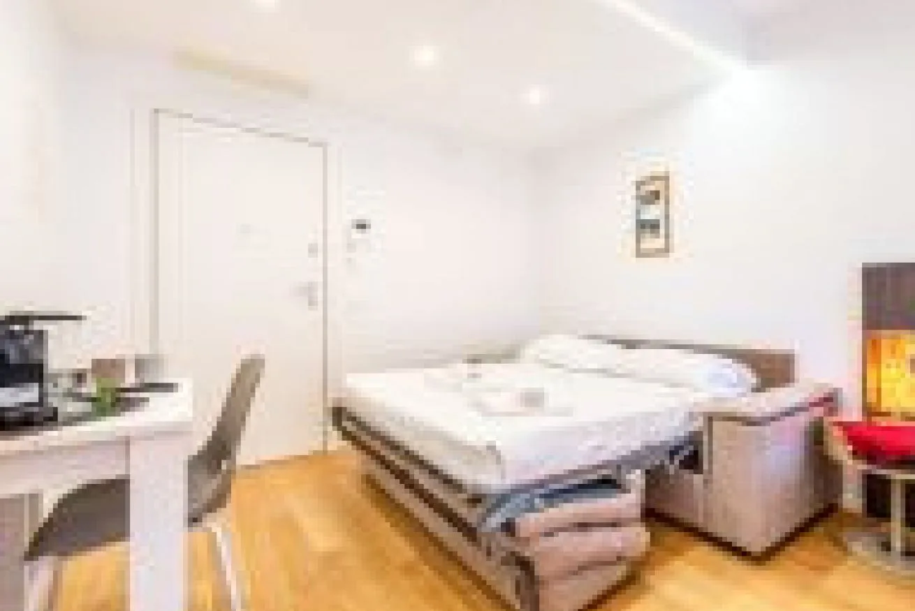 Un dormitorio con una cama, un escritorio y una silla.