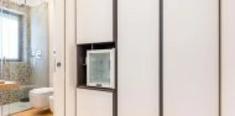 Un baño con una ducha de vidrio y un lavabo montado en la pared.