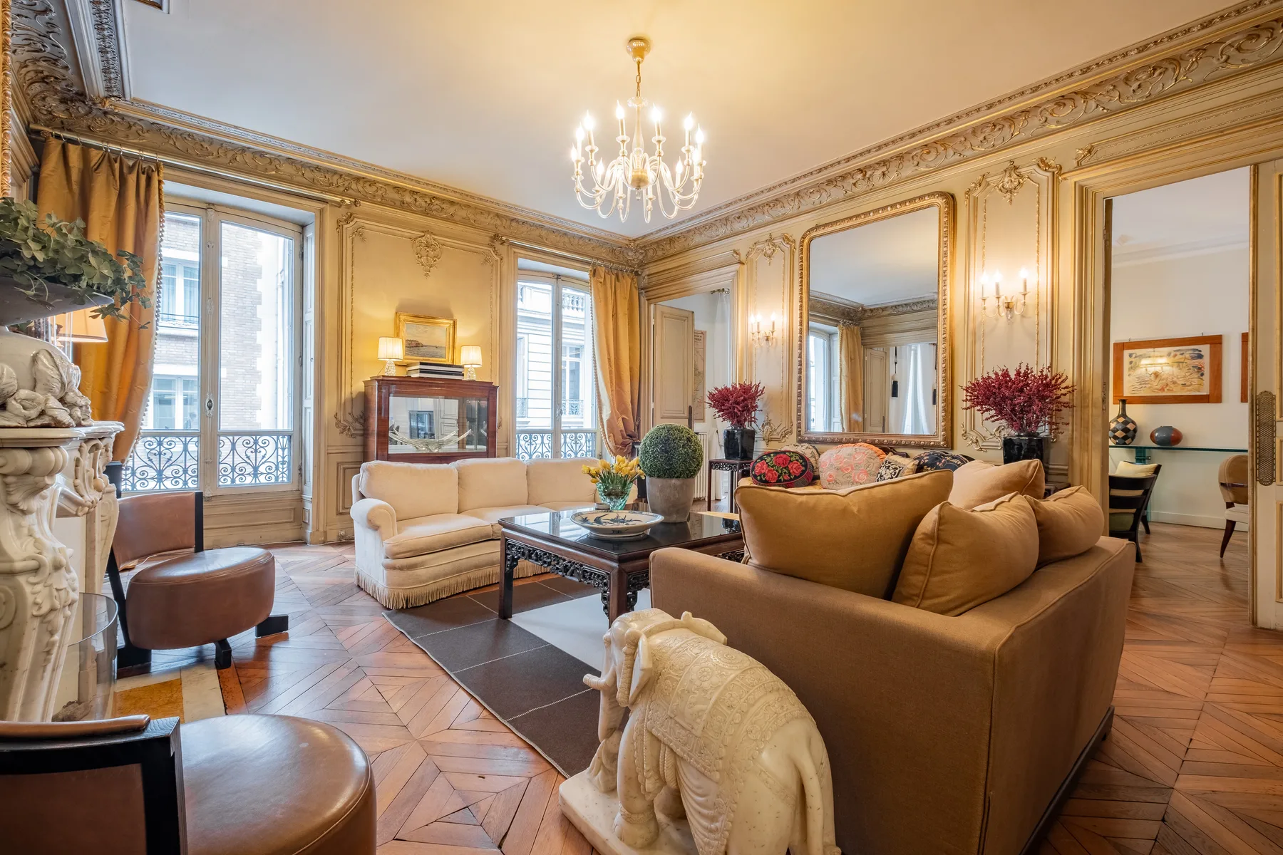 An ornate living room with seating arranged around a coffee table.