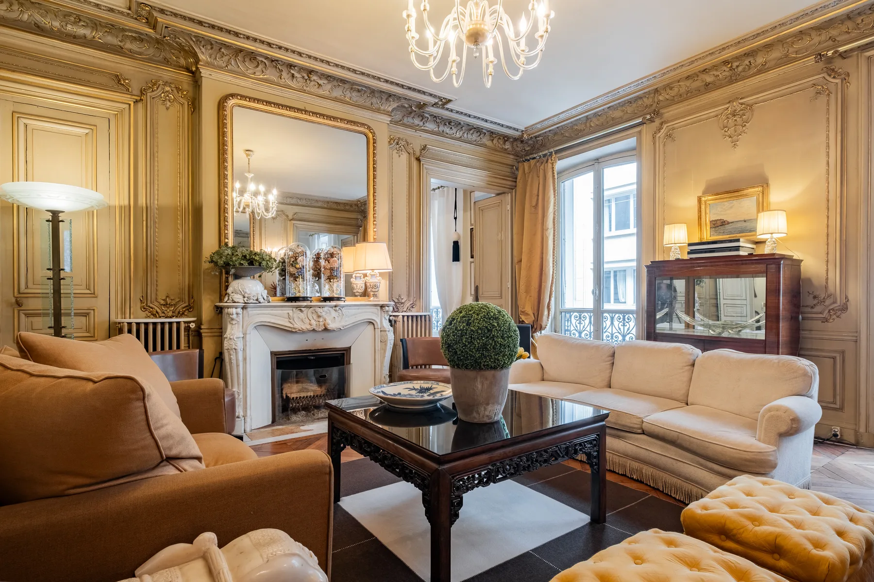 An ornate living room with seating arranged around a dark coffee table.