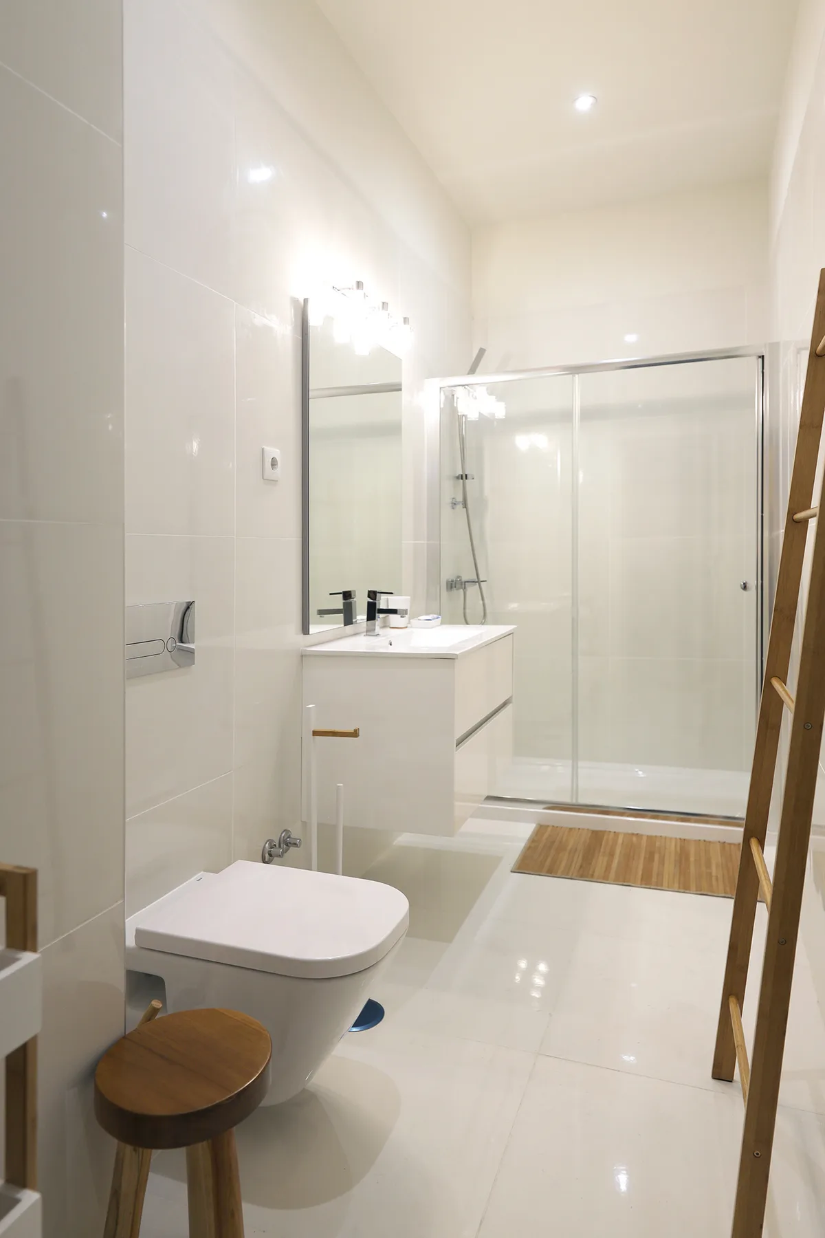 A bright bathroom with a vanity, toilet, and glass shower.