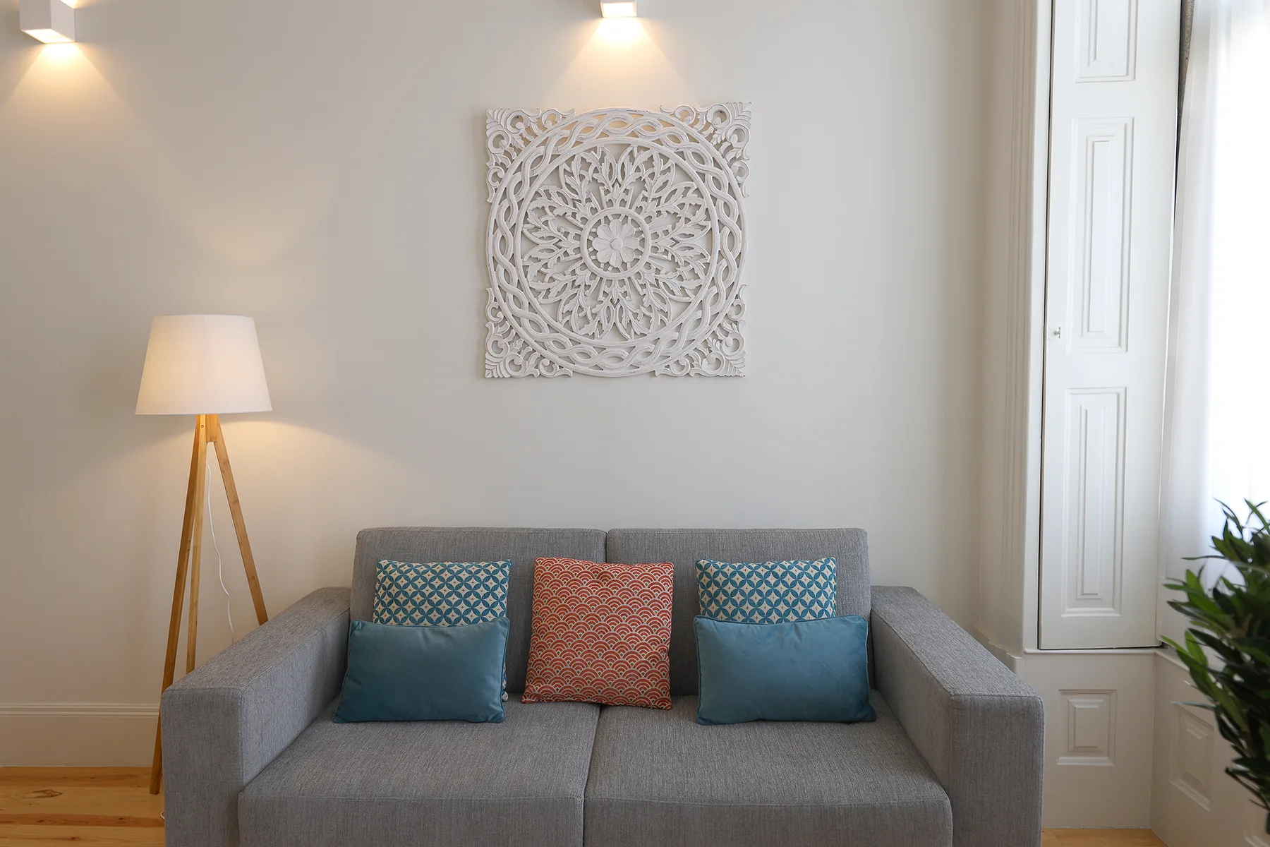 A living room with gray seating and decorative wall art.