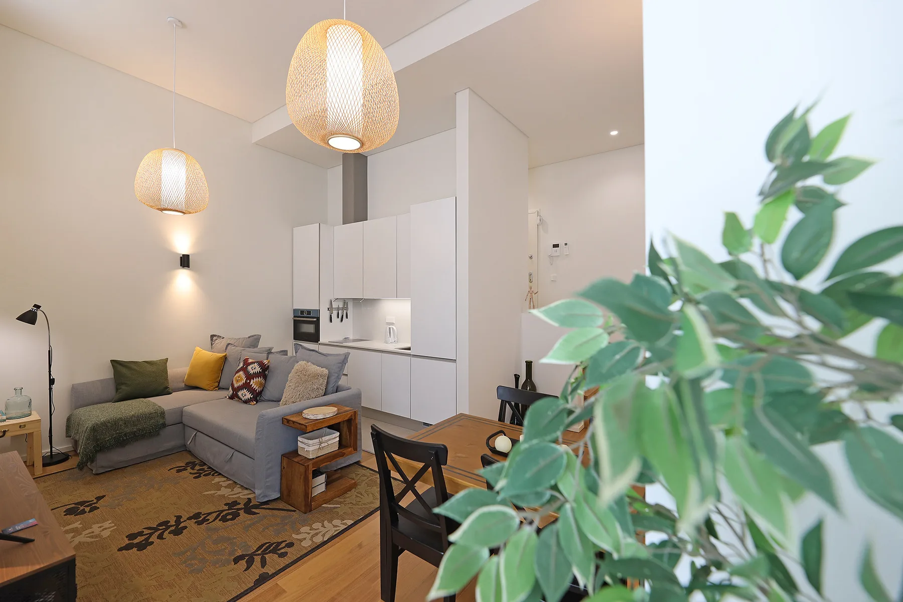 A living area with a sectional seating arrangement and an open kitchen.