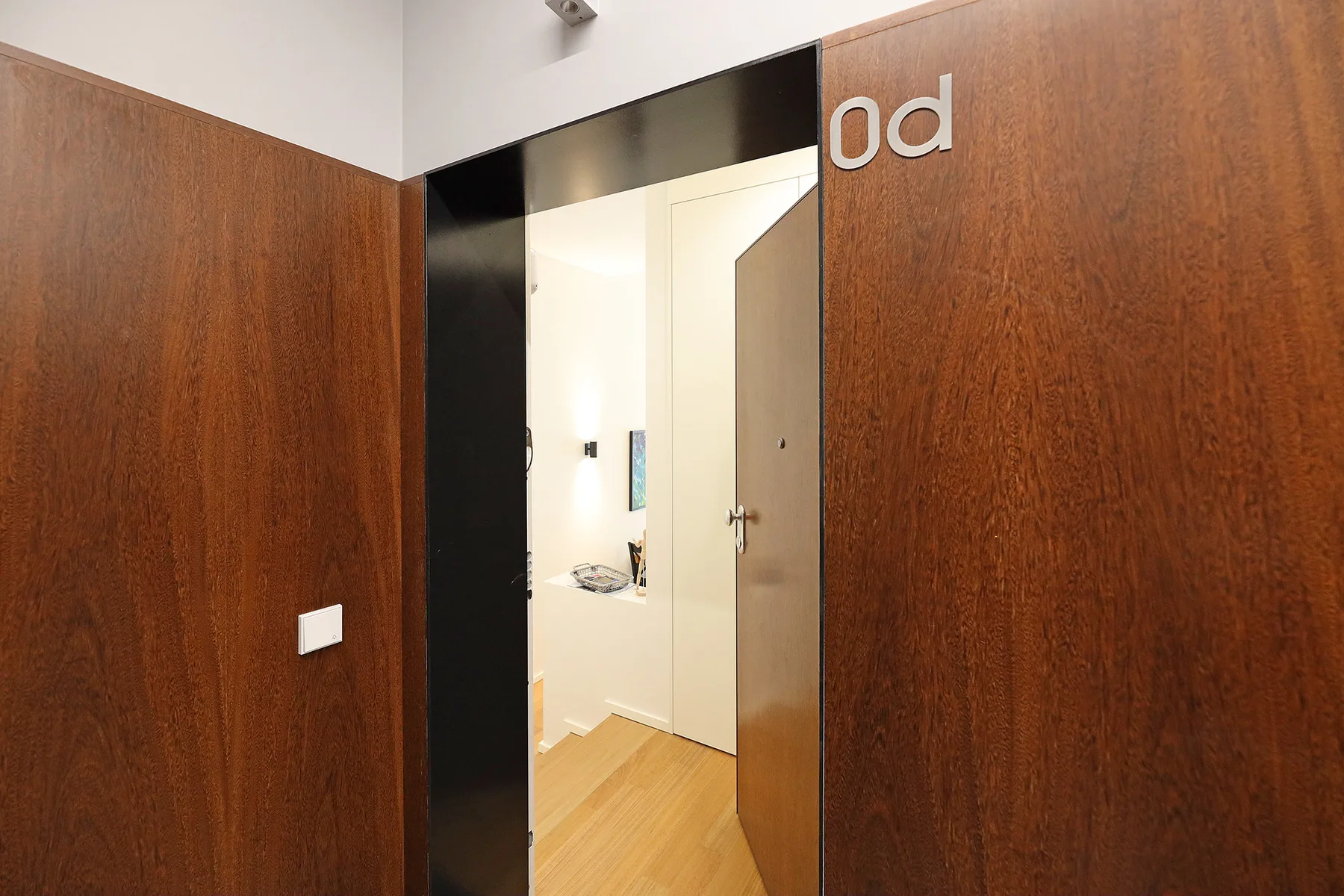A hallway entrance with wooden doors opens onto a bright interior.