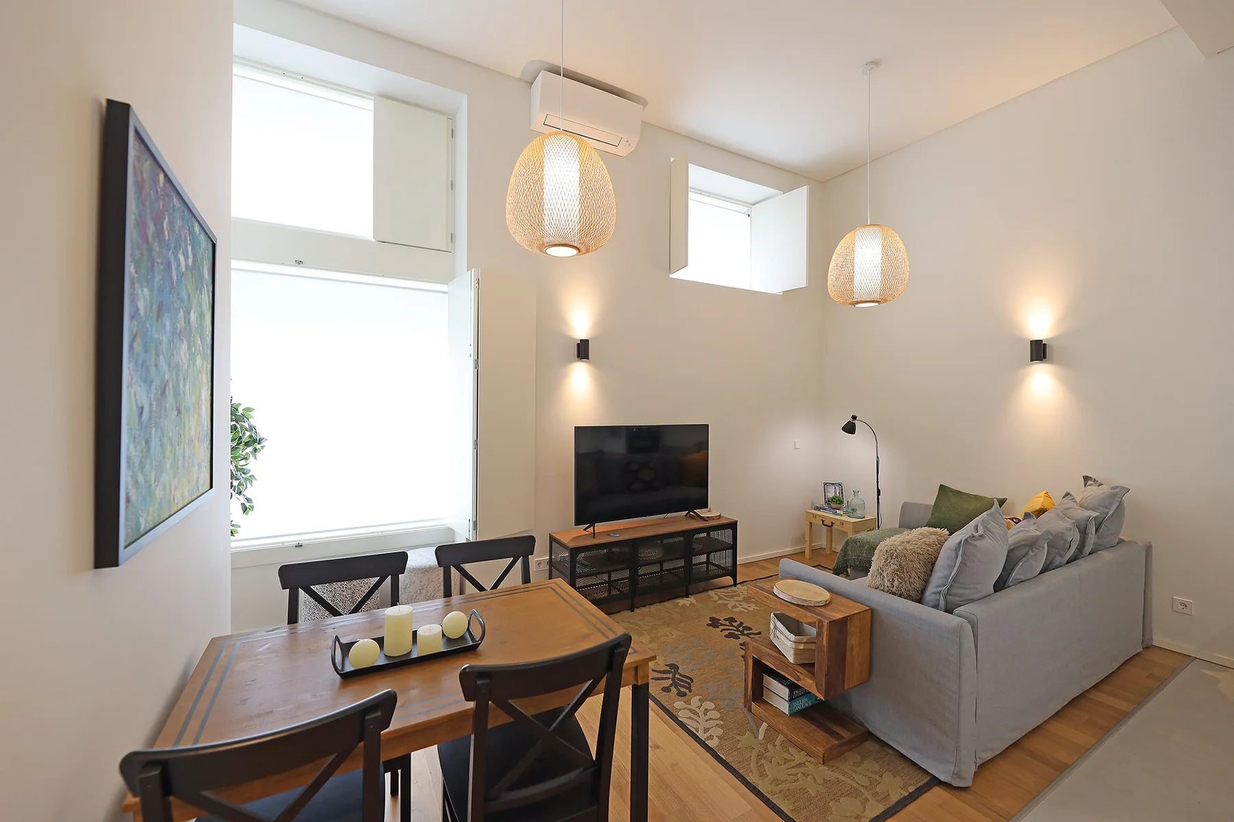 A living and dining area with a television, seating, and a wooden table.