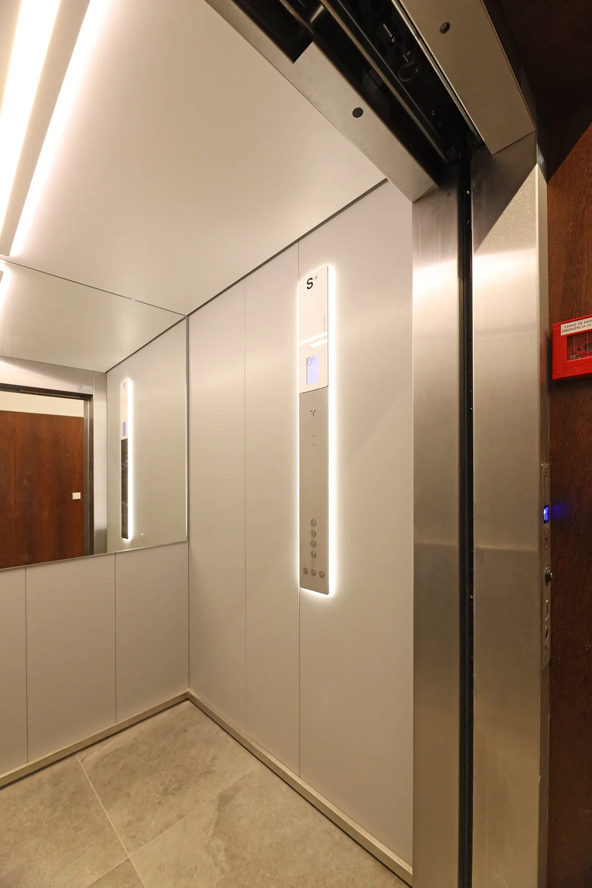 An elevator interior with illuminated floor buttons and mirrored wall panels.