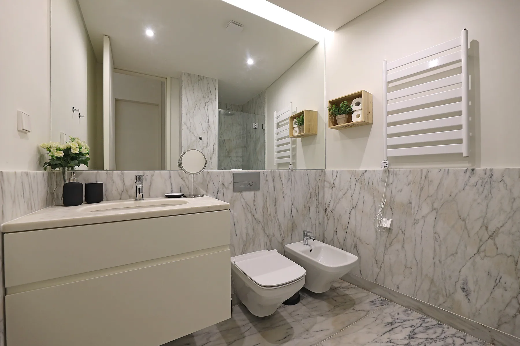 A modern bathroom with a sink, toilet, and bidet.