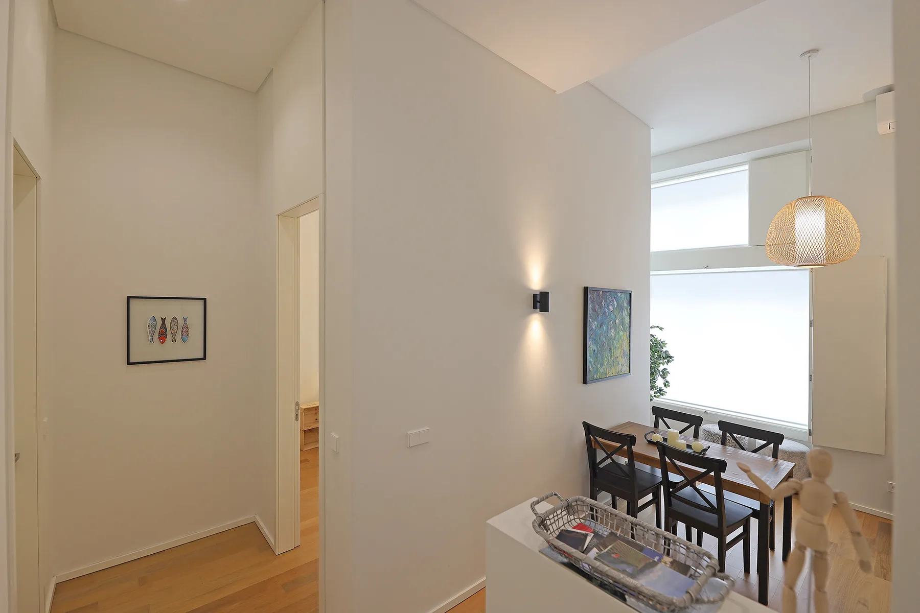 A bright dining area with a table, chairs, and large windows.