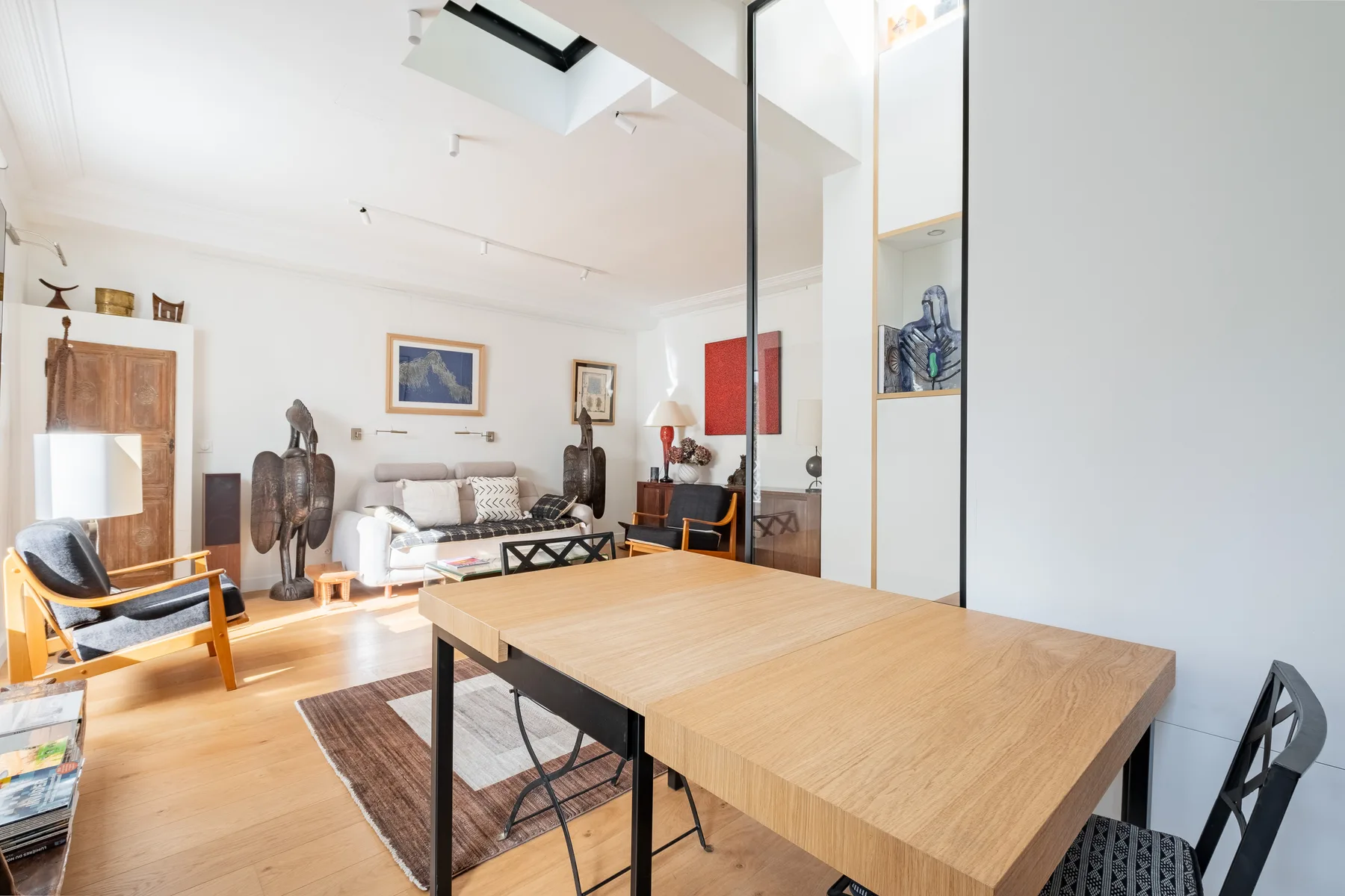 A bright living room with a large wooden table and seating.