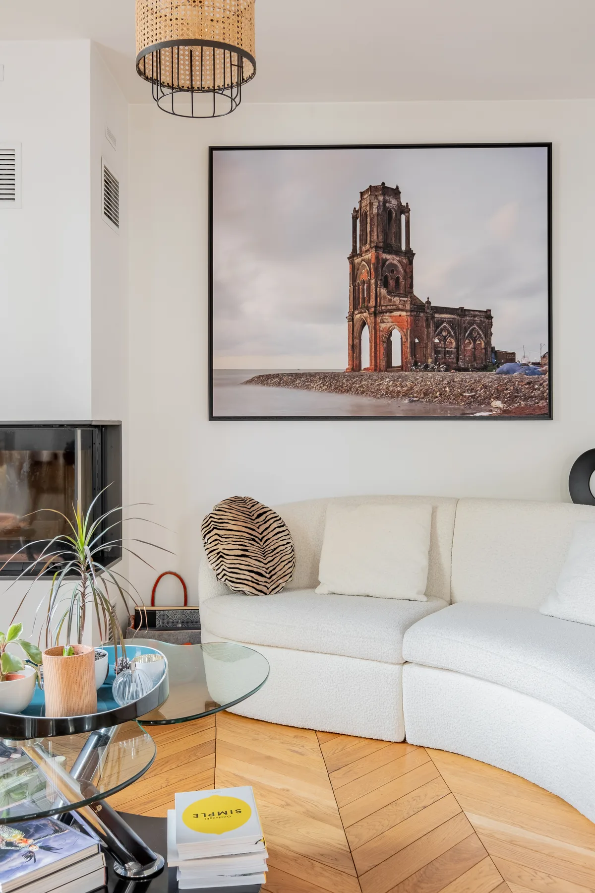 A bright living room with a white sectional sofa and framed wall art.