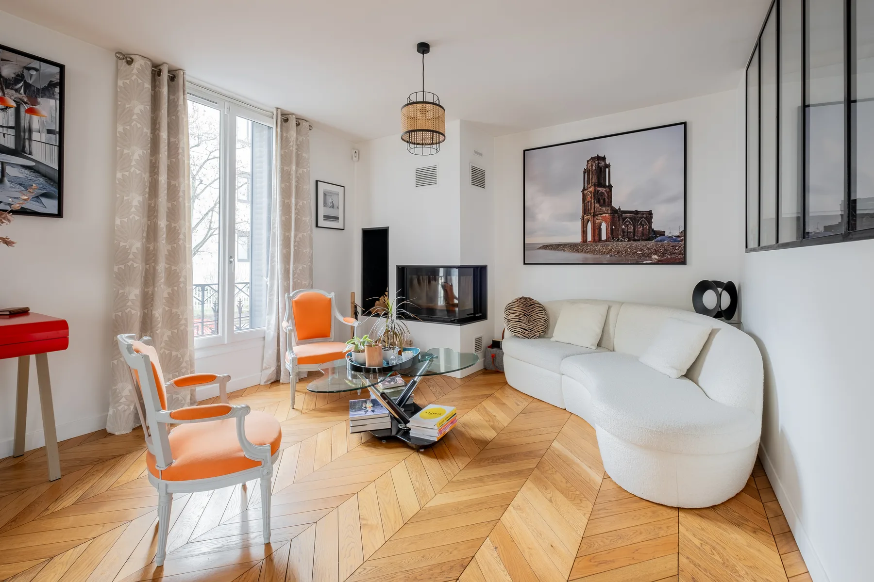 A bright living room with seating around a glass coffee table and television.