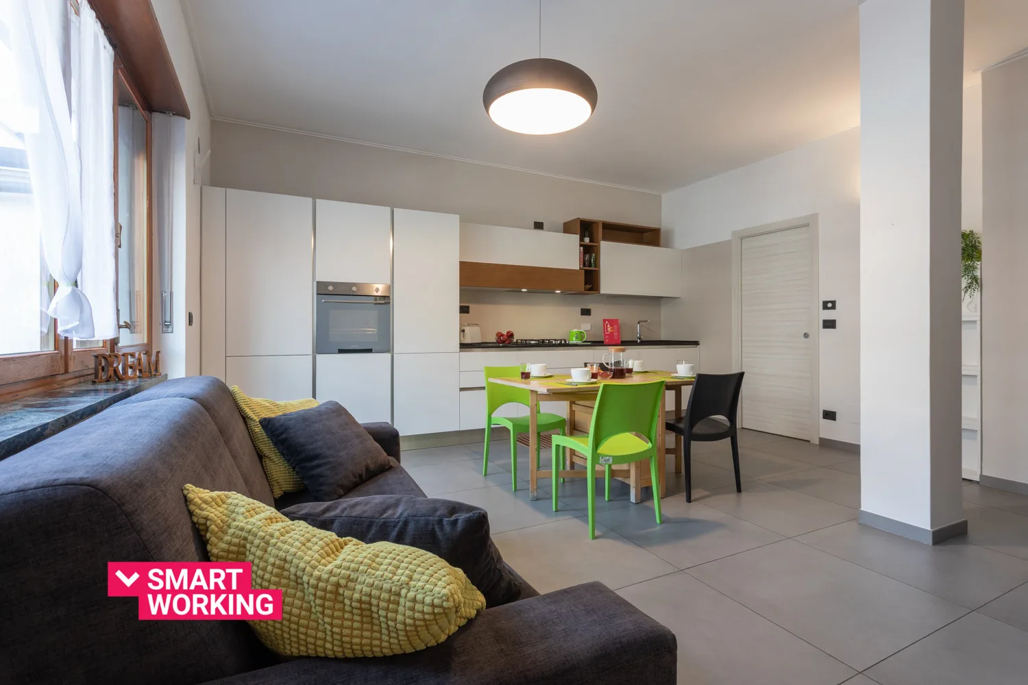 A living and dining area with a sofa, dining table, and colorful chairs.