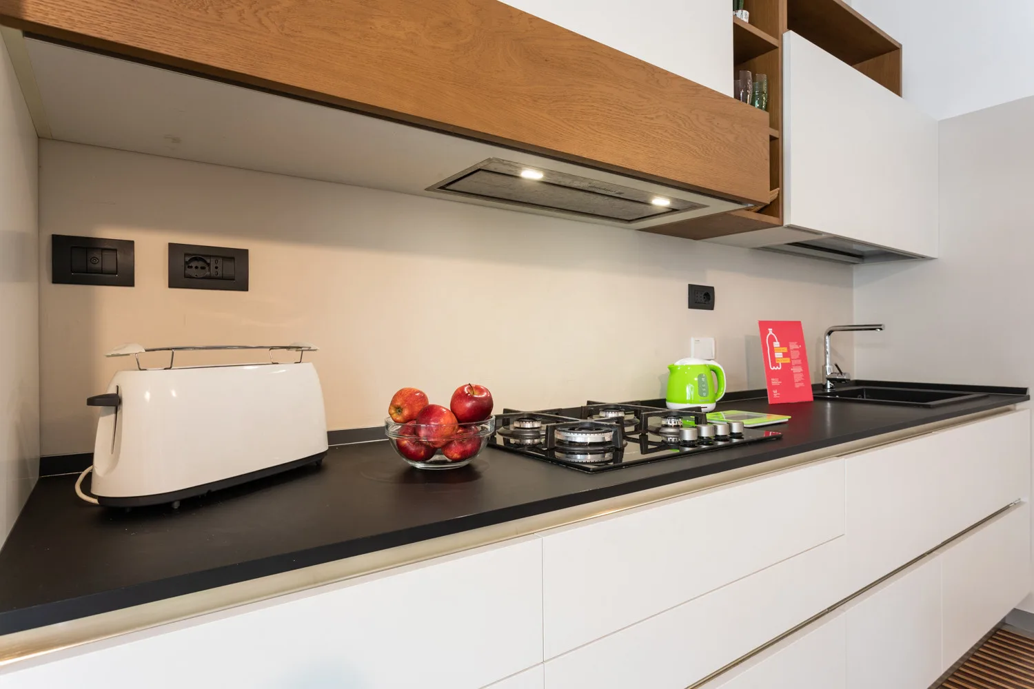 A modern kitchen counter with a cooktop and small appliances.
