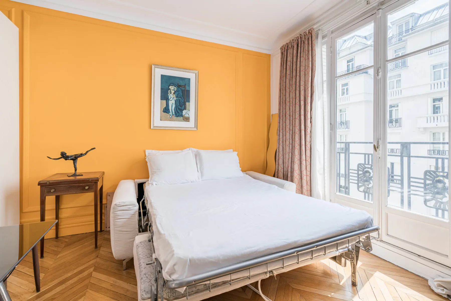 Un dormitorio con una cama junto a grandes ventanas.