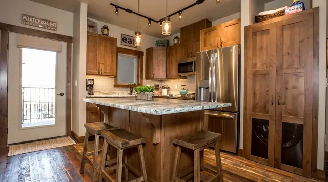A kitchen with wooden cabinets, a central island, and stainless steel appliances.