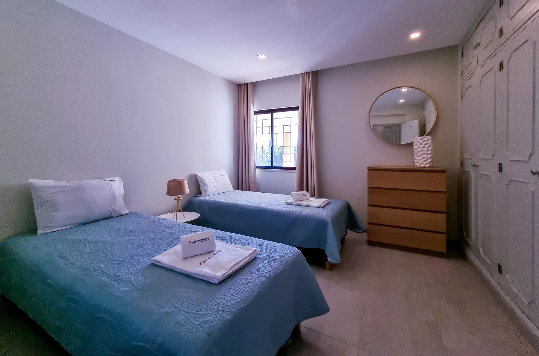 Dormitorio con dos camas, una cómoda y una ventana.