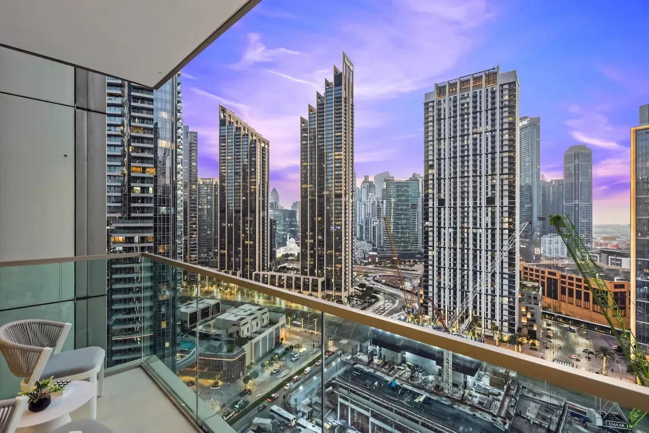 Un balcón ofrece vistas del horizonte urbano con edificios altos.