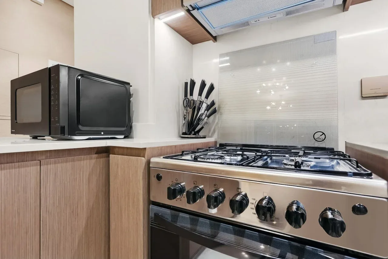 Una cocina con una estufa de gas y un microondas sobre la encimera.