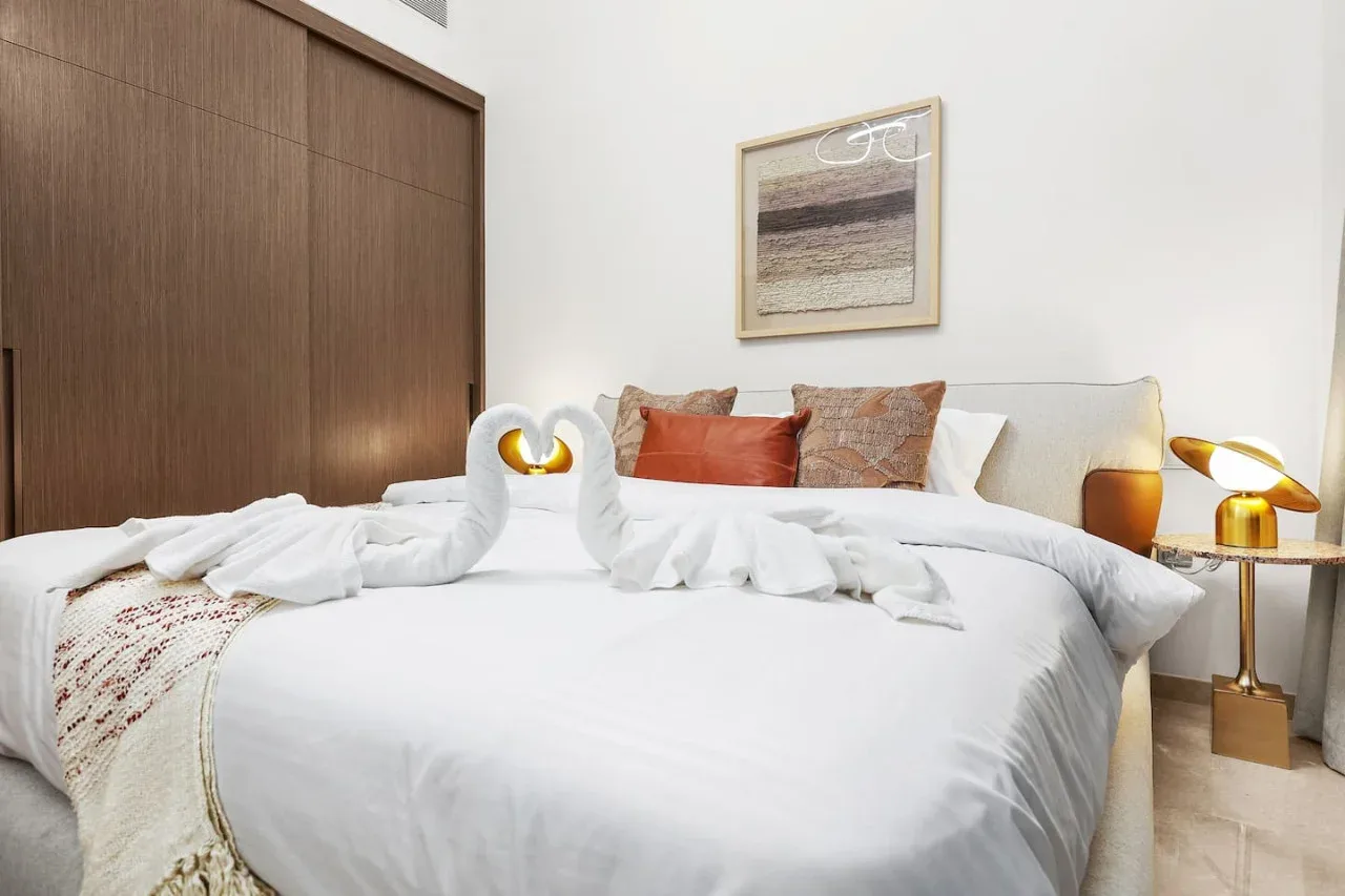 Un dormitorio con una cama bien tendida y un cuadro enmarcado encima.
