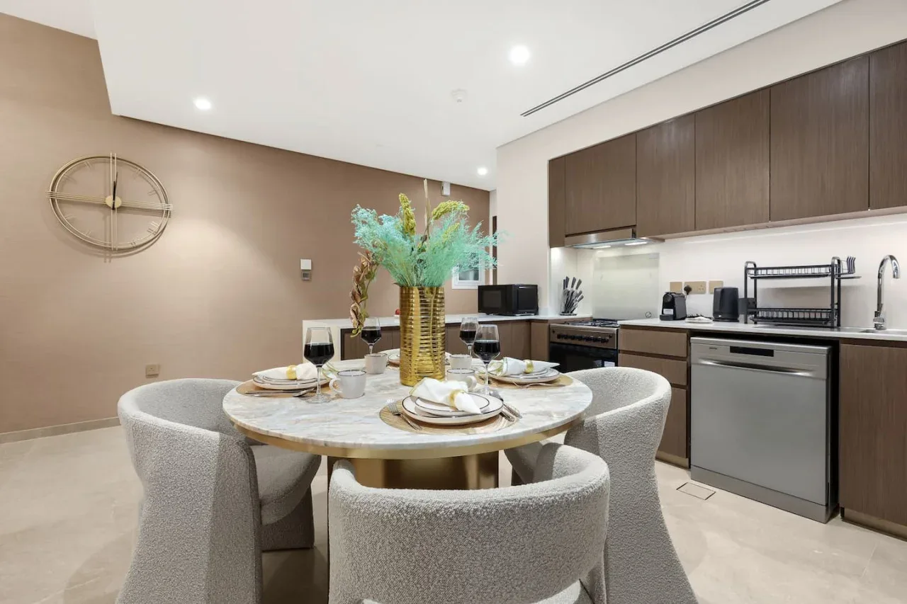 Un comedor con una mesa redonda junto a una cocina moderna.