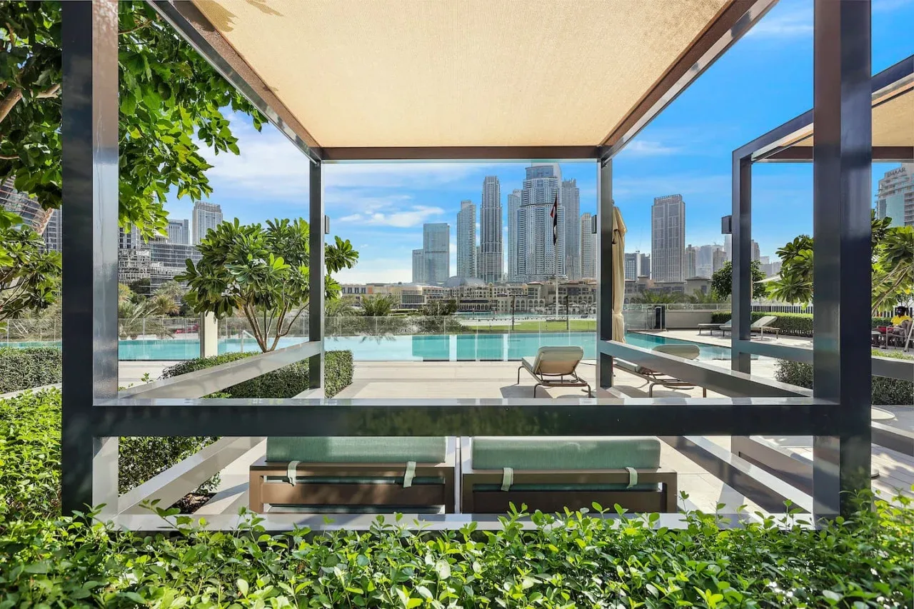 Una terraza con piscina en la azotea ofrece vistas al horizonte urbano, con asientos bajo un toldo.
