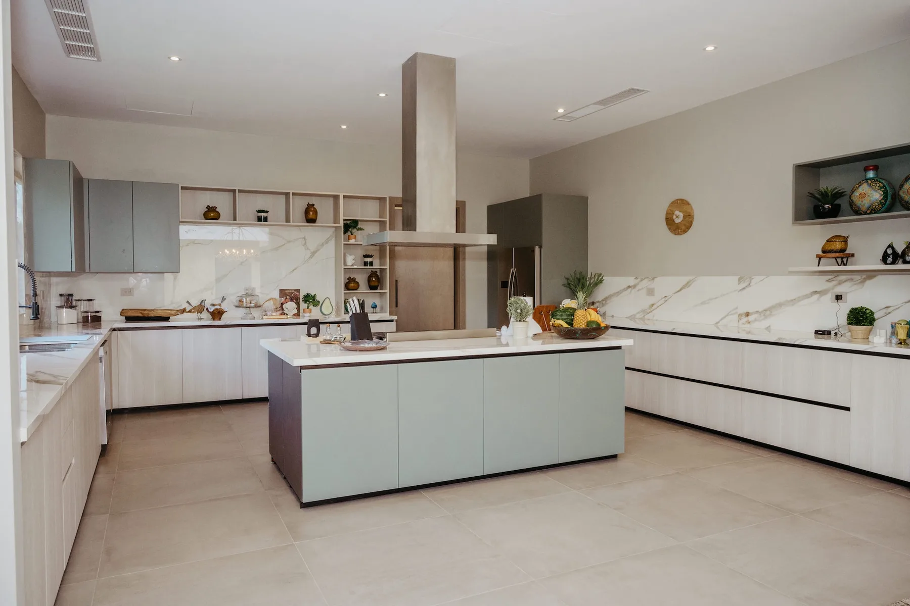 Una cocina moderna con una isla central y gabinetes claros.