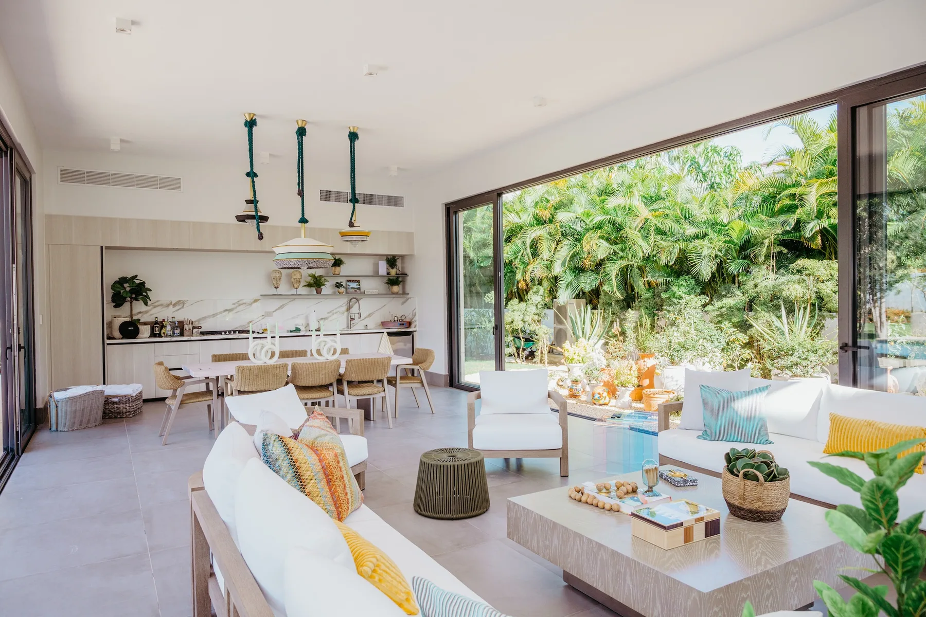 Una sala-comedor de planta abierta con cocina y un gran ventanal hacia el jardín.