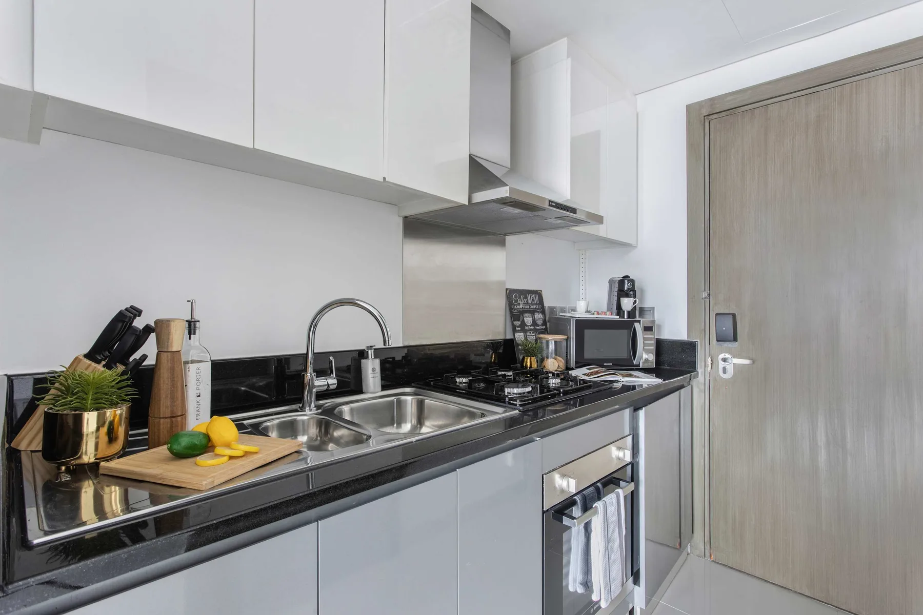 Una cocina moderna con encimera oscura, fregadero y electrodomésticos.