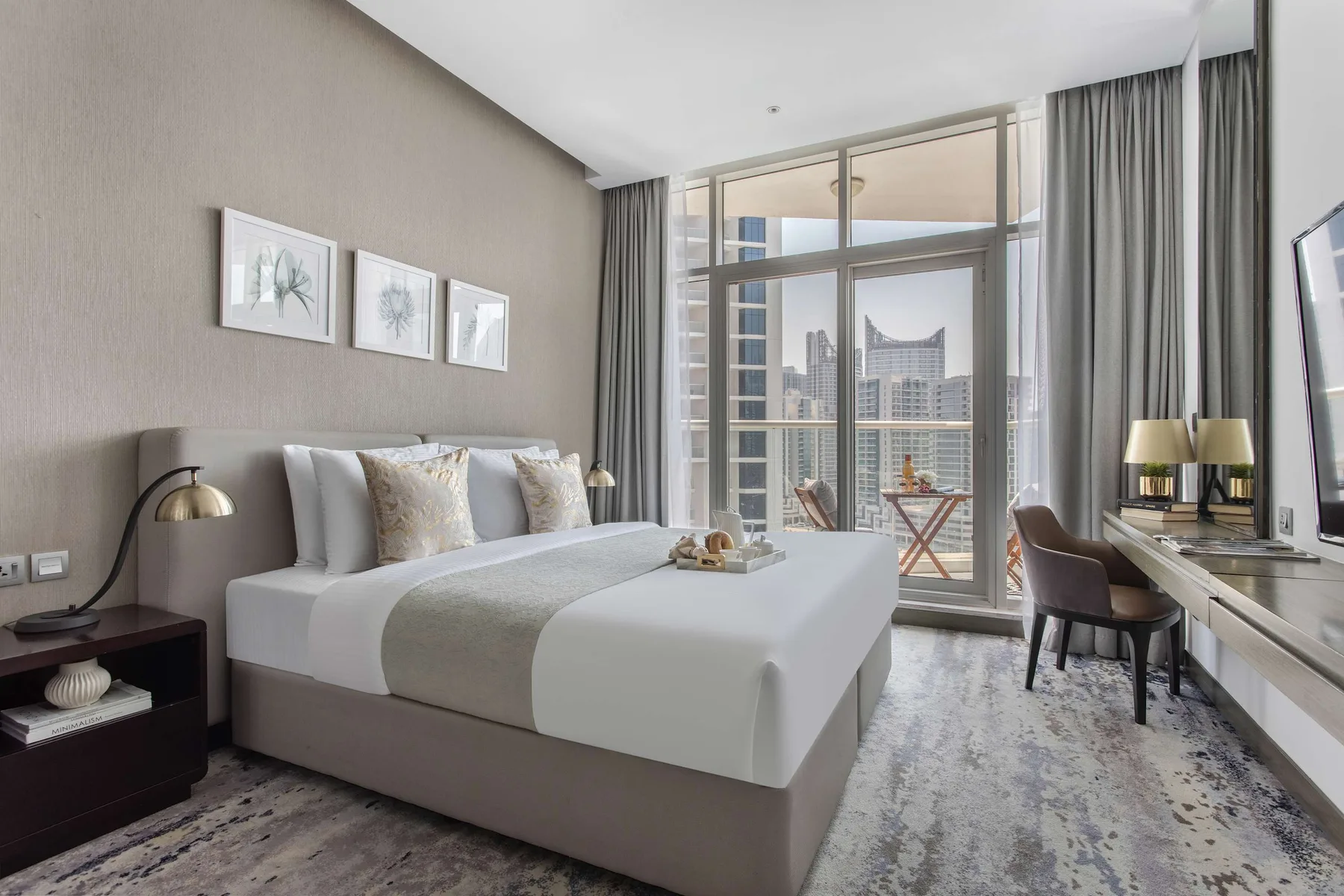 Dormitorio con una cama junto a ventanales con vistas a la ciudad.