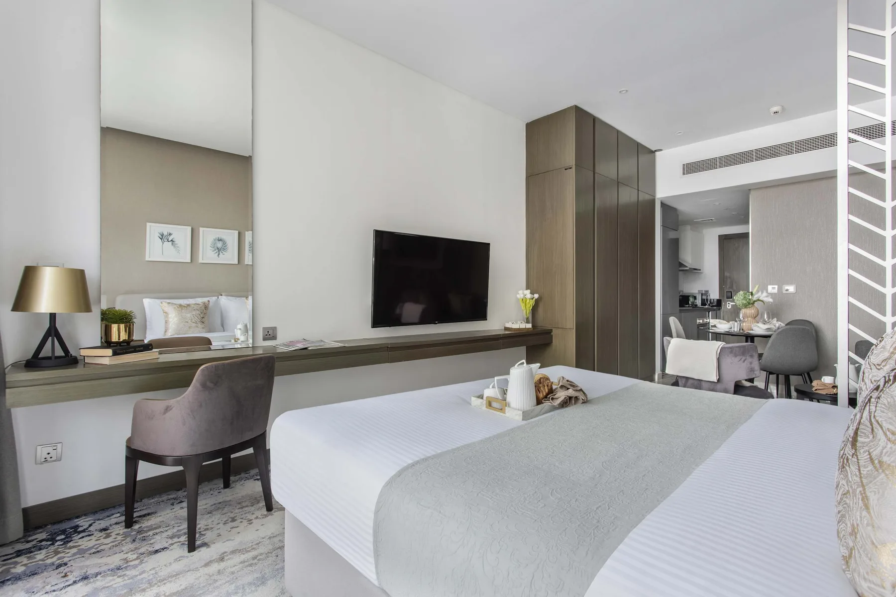 Un dormitorio con cama, televisor montado en la pared y escritorio.
