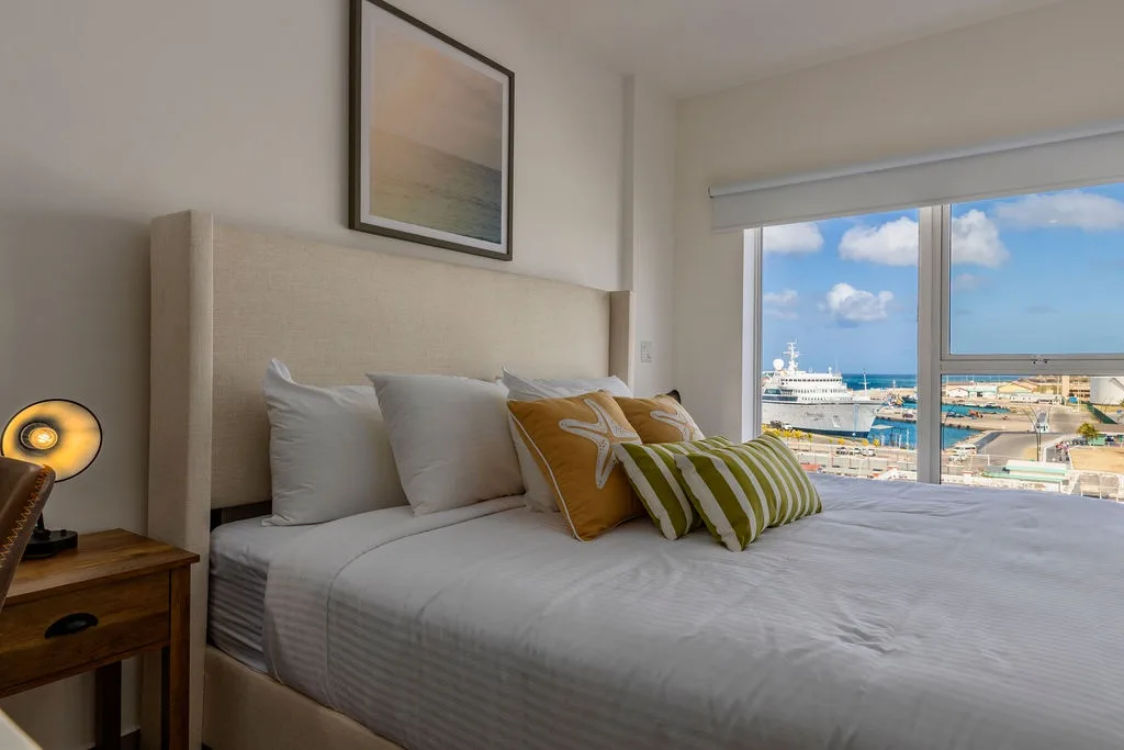 Unwind in your tranquil bedroom with a stunning harbor view. Imagine waking to sunshine over the water through your floor-to-ceiling windows and relaxing in crisp linens after a day exploring.