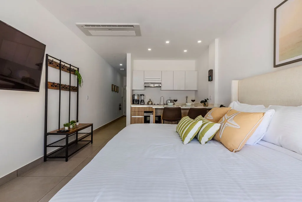Unwind in your modern studio suite where fresh bedding, a fully equipped kitchenette, and calming decor create your perfect home away from home.