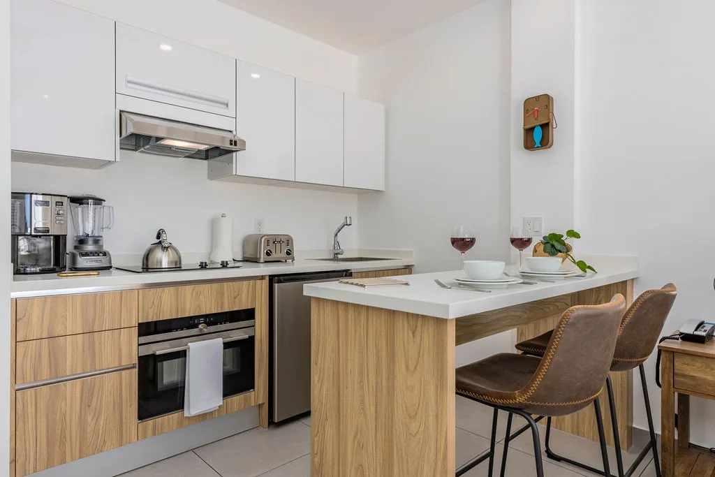 Your fully equipped kitchen invites you to prepare meals with modern appliances, sleek white cabinetry, and a breakfast bar perfect for casual dining.