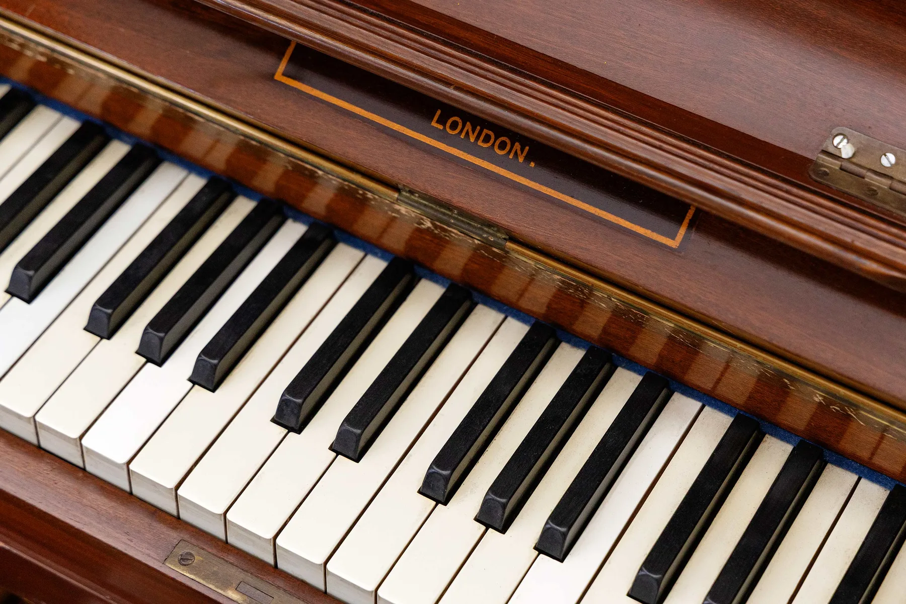 Primer plano de un teclado de piano, con «London» impreso en la madera sobre las teclas.