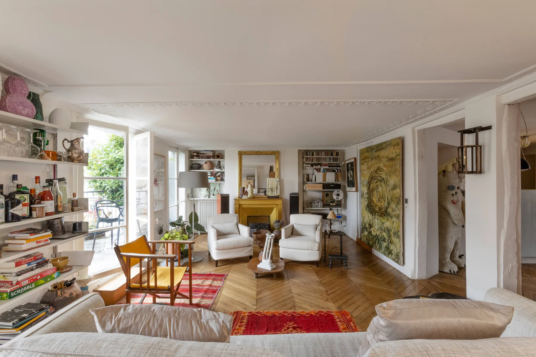Una sala luminosa con asientos, estanterías y ventanas altas que dan a un balcón.