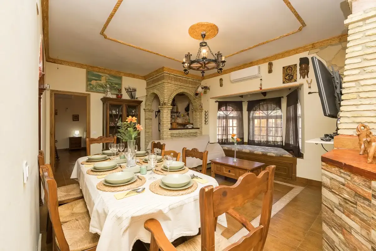 A dining room with a set table and a brick fireplace.