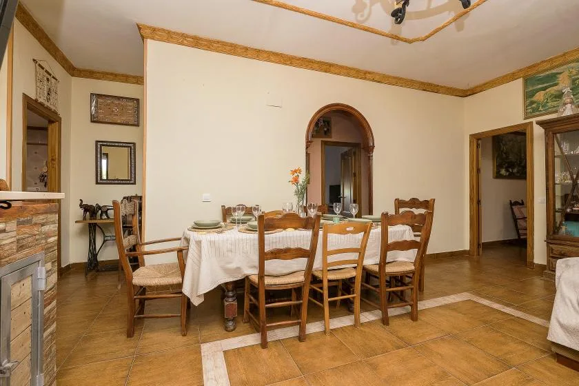 A dining room with a set table and chairs, framed by open doorways.