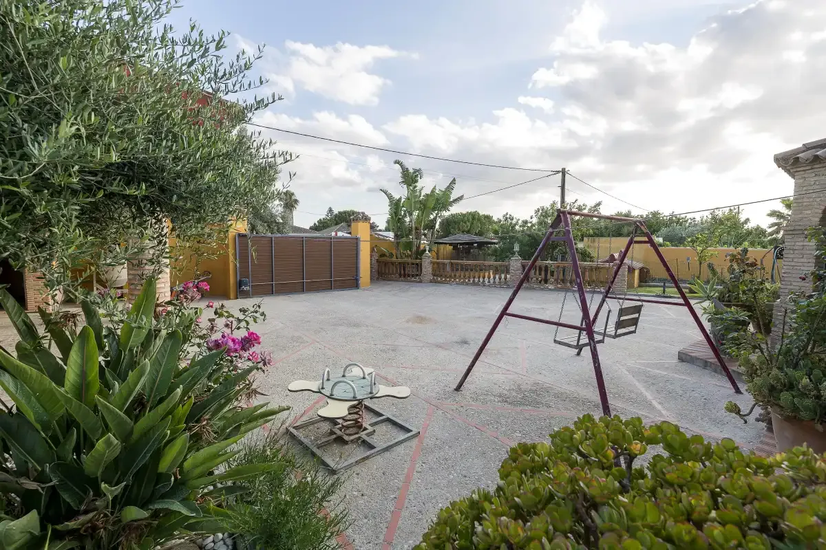 An outdoor play area with a swing set and a small spring rider.