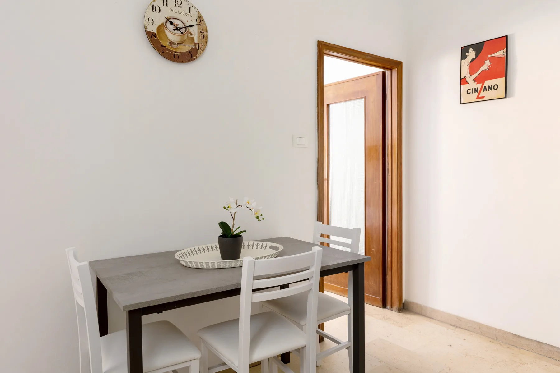 A dining area with a table and chairs beside an open doorway.
