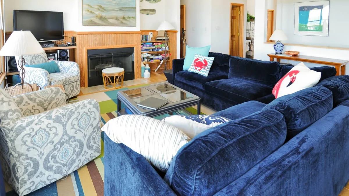 A living room with blue seating arranged around a glass coffee table.