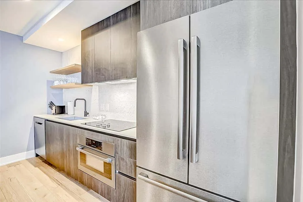Una cocina moderna con refrigerador de acero inoxidable y horno integrado.