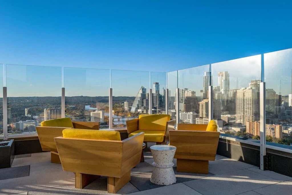 Una terraza al aire libre con asientos ofrece vistas al horizonte de la ciudad.