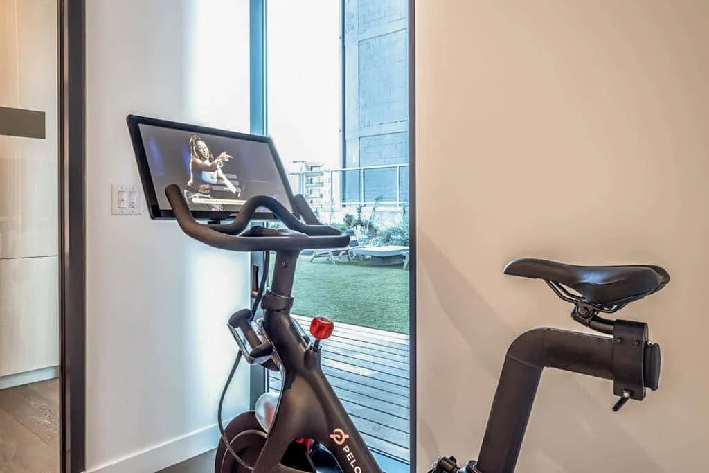 Una bicicleta estática está junto a una ventana de suelo a techo.