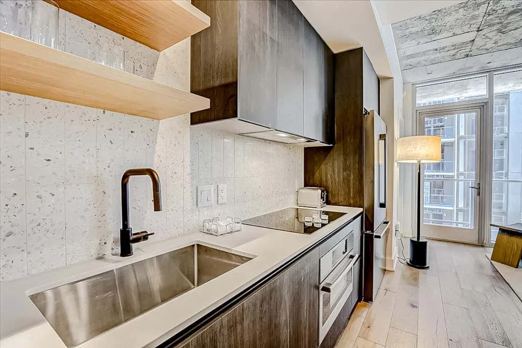 Una cocina moderna con fregadero, encimera y grandes ventanas.