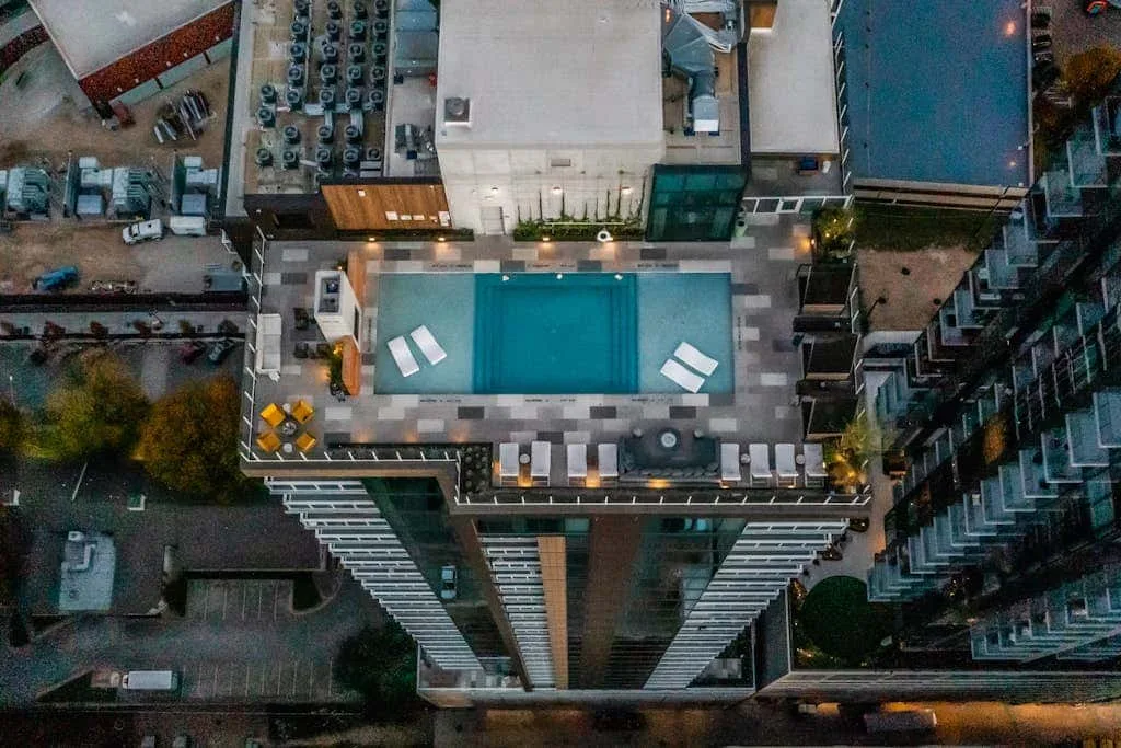 Vista aérea de una piscina en la azotea rodeada de tumbonas.