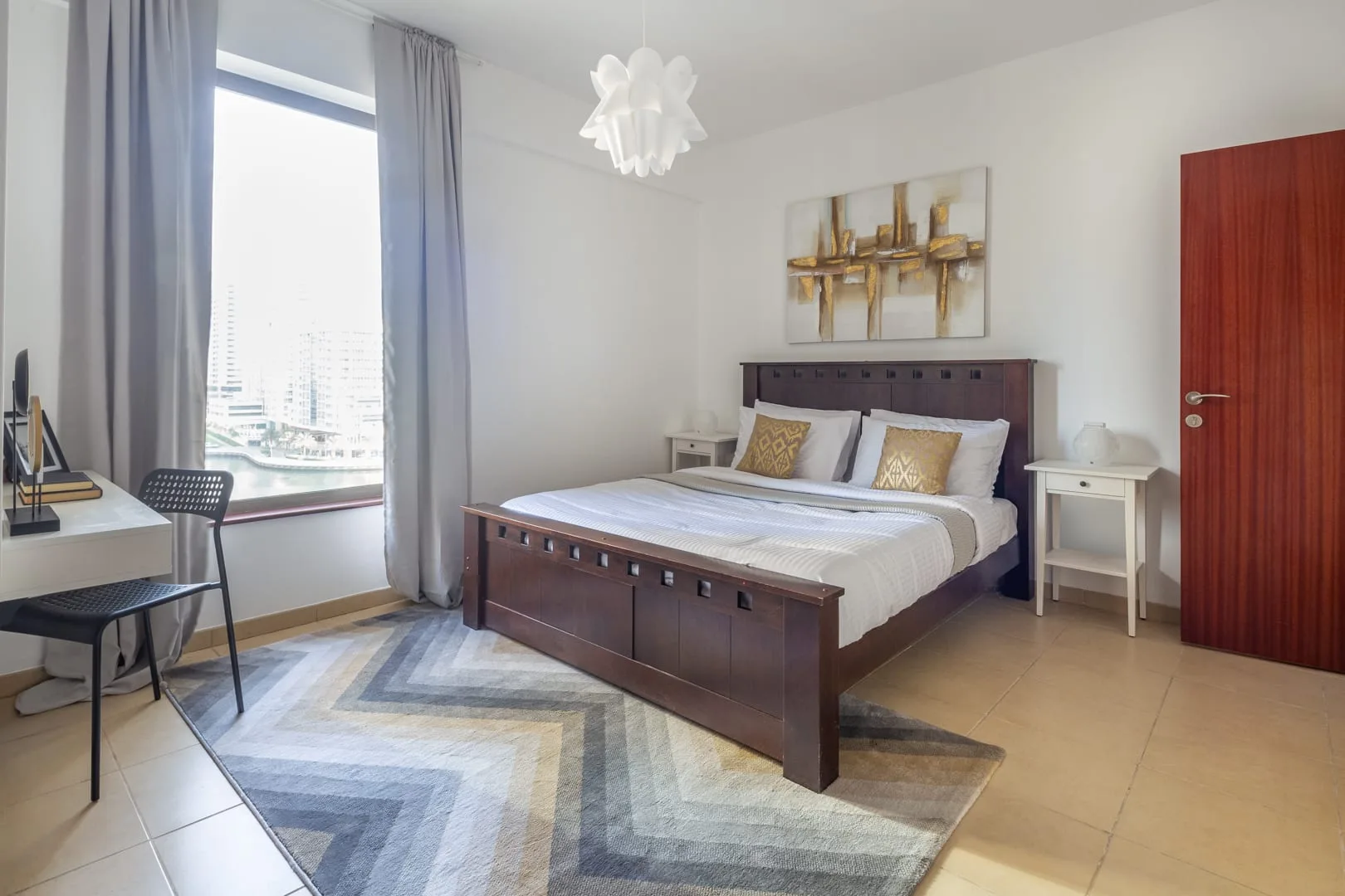 Un dormitorio con una cama de madera oscura, mesitas de noche y una ventana grande.