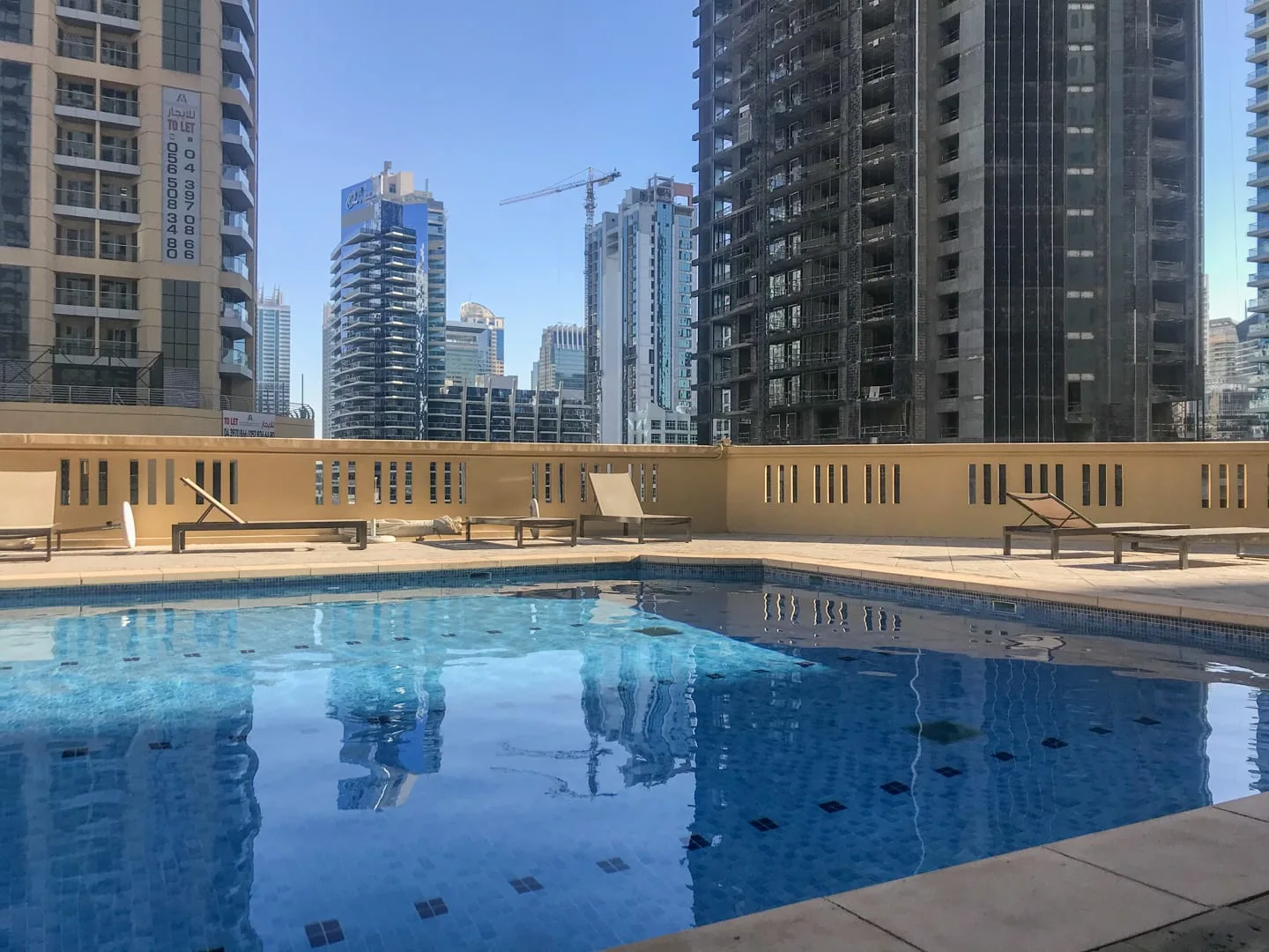 Una piscina en la azotea ofrece vistas de varios edificios altos.