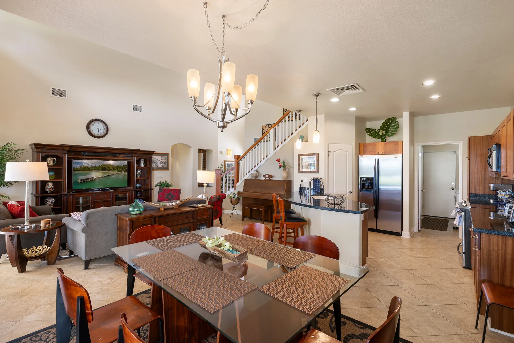 Un espacio abierto de sala, comedor y cocina con una mesa de comedor y una escalera.