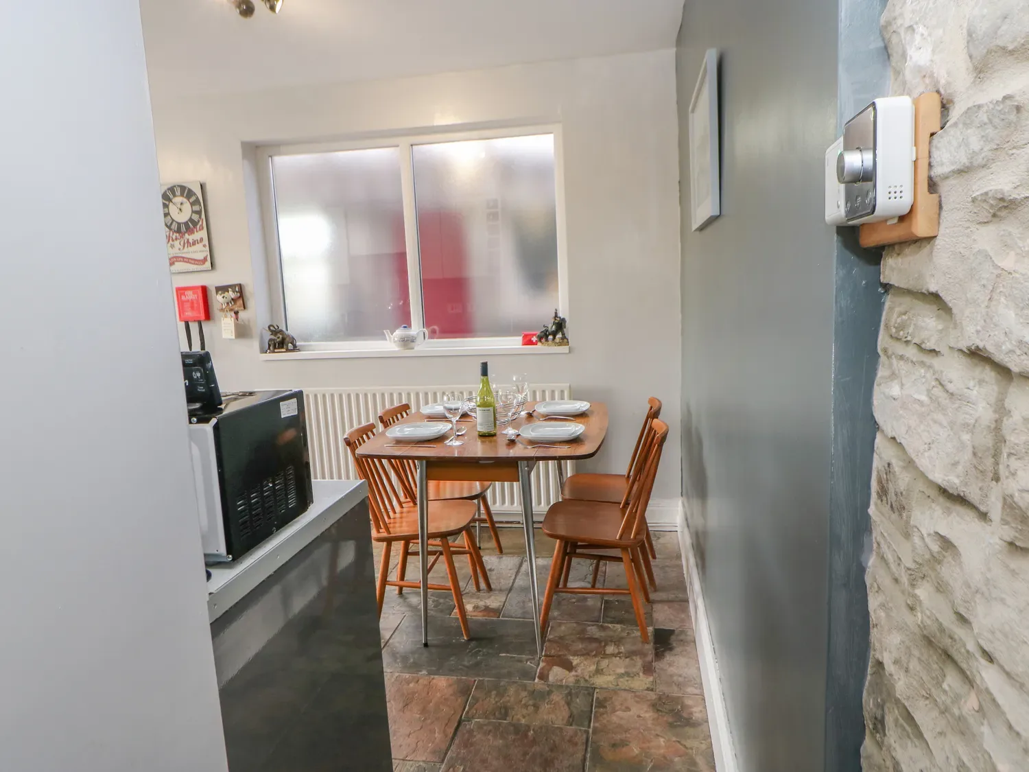 Un comedor con una mesa y sillas junto a una ventana translúcida.