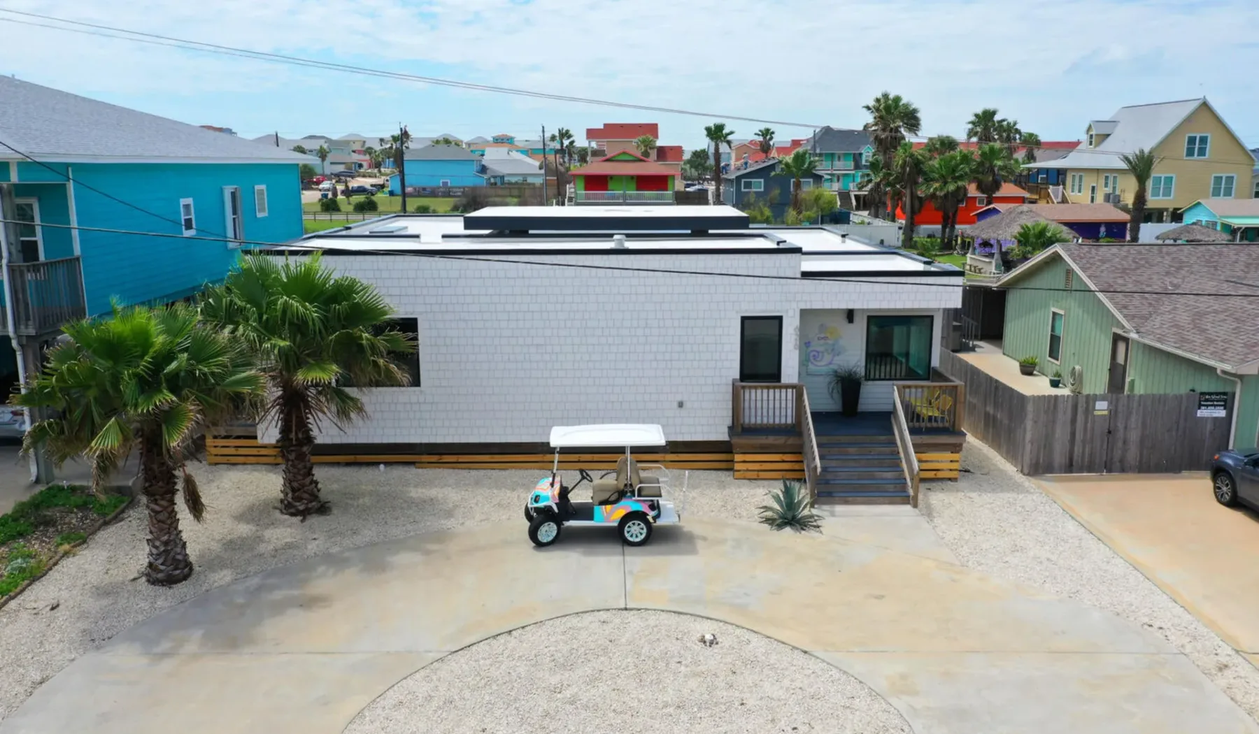 Aerial view of a low-rise building with a small golf cart parked outside.